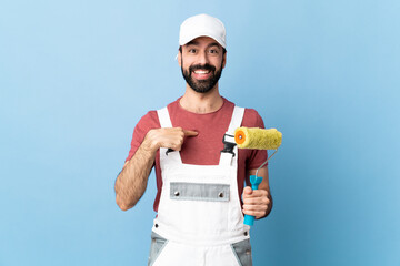Adult painter man over isolated blue background with surprise facial expression