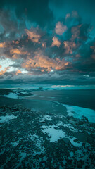 Fototapeta premium Stunning coastal landscape with rugged terrain, icy patches, and dramatic clouds at sunset, creating a serene and picturesque atmosphere, perfect for nature enthusiasts