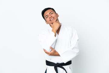 Young Ecuadorian man doing karate isolated on white background happy and smiling