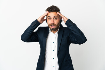 Telemarketer man working with a headset isolated on white background with surprise expression
