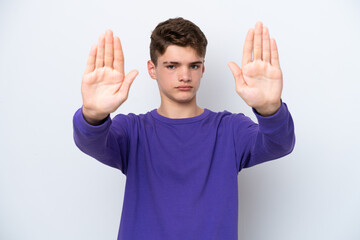 Teenager Russian man isolated on white background making stop gesture and disappointed