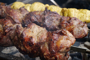 Shish kebabs broil on barbecue. Delicious hot meat. Meat are cooked on hot coals