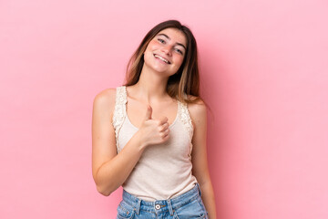 Young caucasian woman isolated on pink background giving a thumbs up gesture