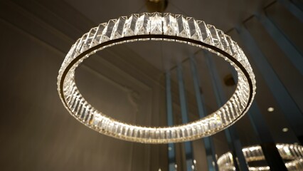 Modern round crystal chandelier hanging from ceiling.
