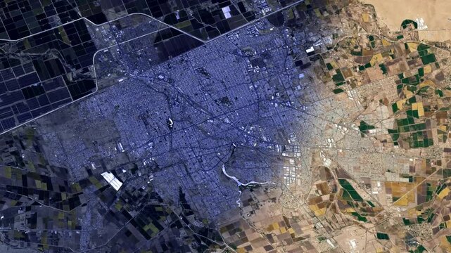 Sunrise time lapse flying over city satellite aerial view of Mexicali, Baja California, Mexico. Animation based on image by Nasa