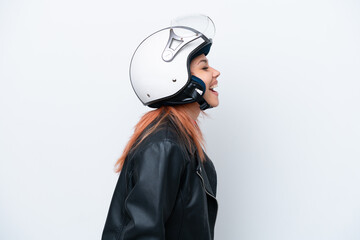 Young Russian girl with a motorcycle helmet isolated on white background laughing in lateral position