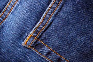 Worn denim trousers. Machine stitch close up. Denim texture in blue. The concept of repairing old clothes. Sewing factory. Fashionable aging clothes.