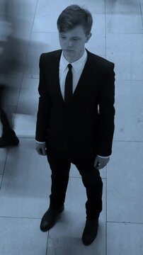 A Mysterious Individual Dressed in Formal Attire Standing Against an Urban Background