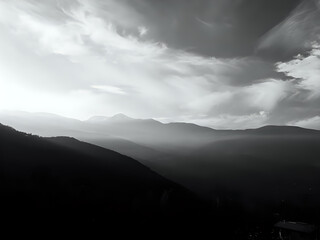 Fototapeta premium A majestic mountain over the hills, surrounded by clouds and a vibrant sky, the sun rises, showcasing the natural beauty and power of this impressive landscape.