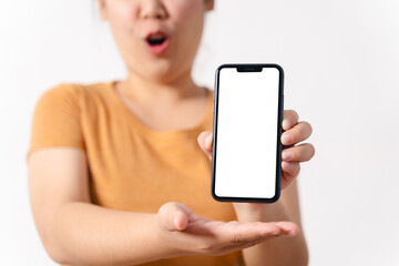 A woman is holding a blank empty white screen smart phone in her hand, her mouth open in surprise