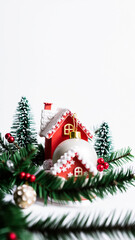 white christmas ornament hanging between two miniature red houses
