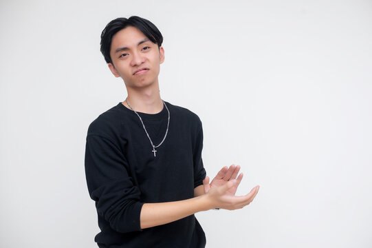 A young asian man giving a sarcastic and begrudging clap with a smirk. He is isolated on a white background, creating a humorous and casual atmosphere.