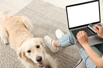 Online pet shop. Woman with laptop, credit card and cute Golden Retriever dog making order at home,...