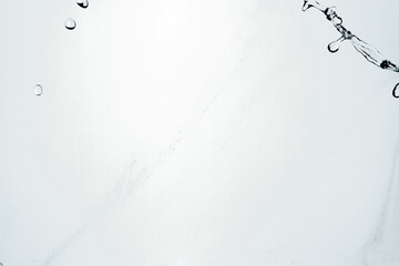 Water splash isolated on blue background. Transparent realistic water with movement and drops. Dynamic flight of water drops.