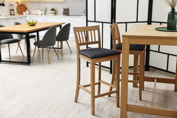 Stylish stools and table near folding screen indoors