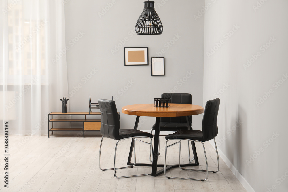 Wall mural Wooden table with black chairs in stylish dining room