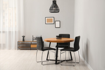 Wooden table with black chairs in stylish dining room