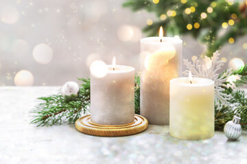 Christmas composition with burning candles on white table, bokeh effect. Festive card