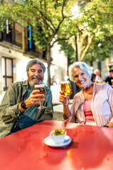 Senior couple enjoying tapas and beer in the city