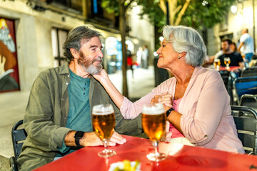 Senior woman caressing the face of her husband at bar