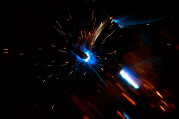 Arc welding. Welding pipes in inert gases. MIG / MAG. A bright flash of light and a sheaf of sparks.