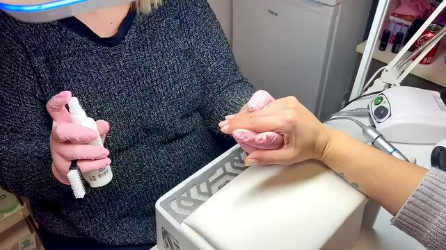 Video of a manicurist applying fixative spray to enhance nail durability