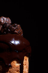 Easter cake on the festive table. Festive baked goods with exuberant spring colors on a dark background. Chocolate candies on melted shiny chocolate.