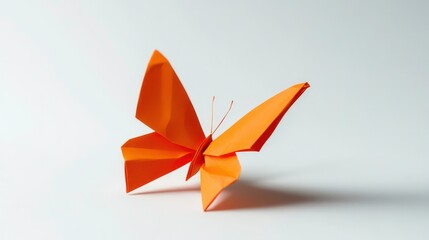 A vibrant orange origami butterfly against a white background.