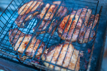 Juicy grilled steaks. Barbecue on the street. Cooking meat on the barrel with a grill.