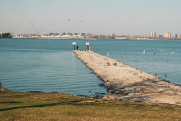 Obraz premium A beach with a pier and a city in the background