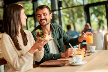 Enjoying a delightful brunch together at a cozy cafe on a sunny afternoon in the heart of the city