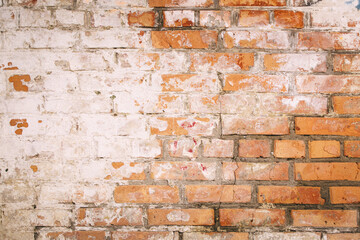 Old grungy brick wall. Free space for an inscription. Can be used as a background or poster. Fragment of a wall with bumps and shabby plaster.