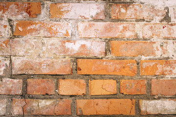 Naklejka premium Old grungy brick wall. Free space for an inscription. Can be used as a background or poster. Fragment of a wall with bumps and shabby plaster.