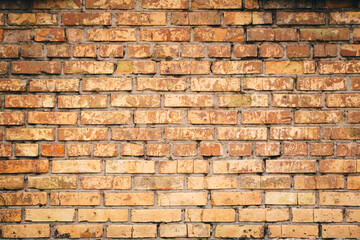 Old grungy brick wall. Free space for an inscription. Can be used as a background or poster. Fragment of a wall with bumps and shabby plaster.