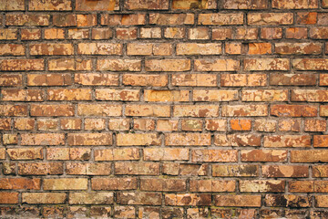 Old grungy brick wall. Free space for an inscription. Can be used as a background or poster. Fragment of a wall with bumps and shabby plaster.