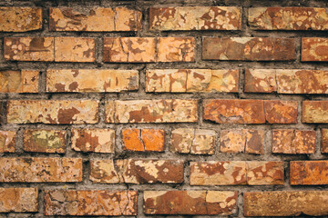 Old grungy brick wall. Free space for an inscription. Can be used as a background or poster. Fragment of a wall with bumps and shabby plaster.