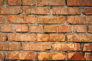 Old grungy brick wall. Free space for an inscription. Can be used as a background or poster. Fragment of a wall with bumps and shabby plaster.