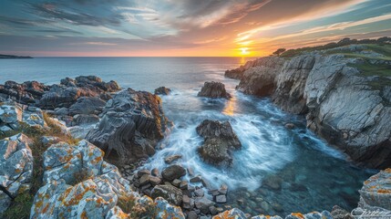 Obraz premium A rugged coastline at sunset, with sharp contrasts between the sea, rocks, and sky
