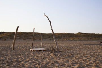 Strandgut am Strand am Meer mit Holzstamm und Palette 