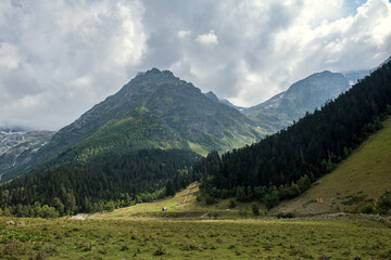 Mountains under cloudy sky in the green valley, North Caucasus, Russia