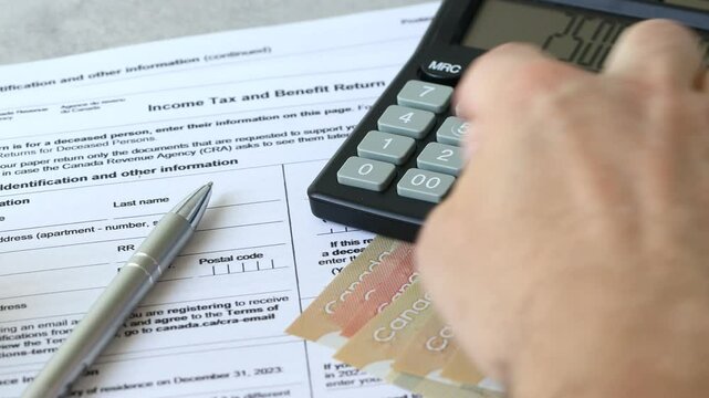 Income tax return in Canada. Financial concept. Tax form, Canadian dollars and tax calculation on calculator. close up