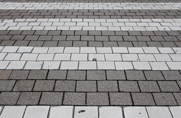 Texture of brown and white square paving tile. Pattern of sidewalk tiles in the street. Concrete pavers close up background.