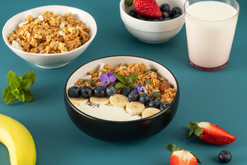 A healthy nutritious breakfast of natural Greek yoghurts, granola and fresh berries.