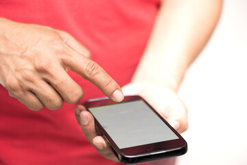 Closeup of men's hands holding cell telephone and white screen with blank copy space for your advertising text message or promotional conten.Hand holding texting using mobile on desk at office.