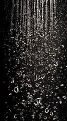 Obraz premium Raindrops cascading in a beautiful, serene manner against a dark background, creating a mesmerizing effect of nature's beauty.