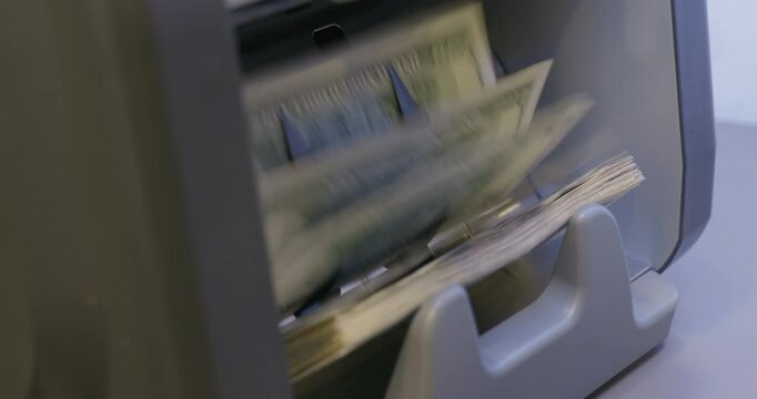 High quality video 6k 4:2:2 10bit downscale 4k .100 dollar bills counted in money counting machine. Cash money dollars into banknote counter. 