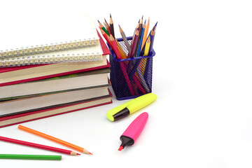 Fototapeta premium Crayon or colored pencils in box with side stack of books and school supplies on with background. Learning, study and office equipment concept.