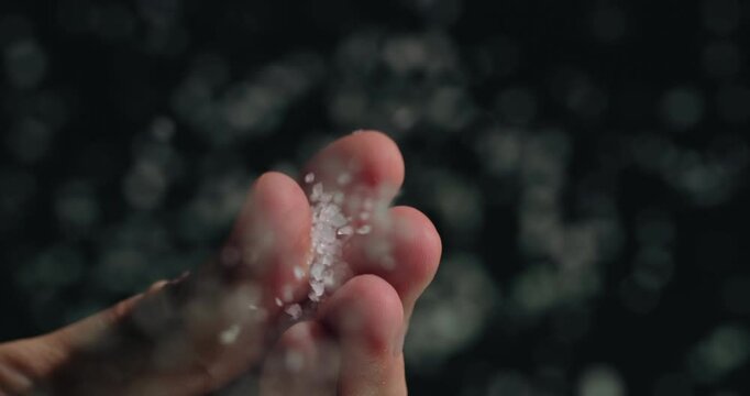 Chef pours salt, close-up low angle shot. Slow motion video