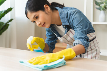 Close-up hand of maid cleaning table during household job.