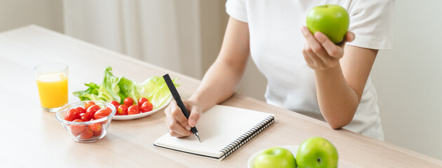 Wellbeing of health with good food control concept. Woman writing the meal note and plan to eat...